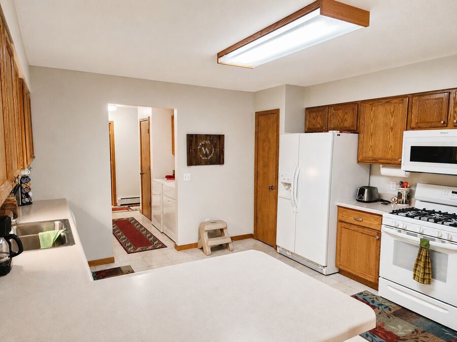 Kitchen with oak cabinetry and peninsula seating
